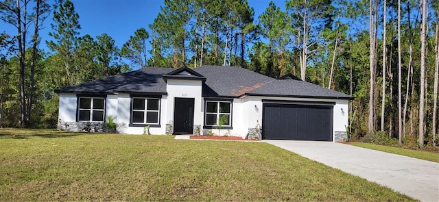 view of front of house featuring a front yard, a garage, driveway, and stucco siding