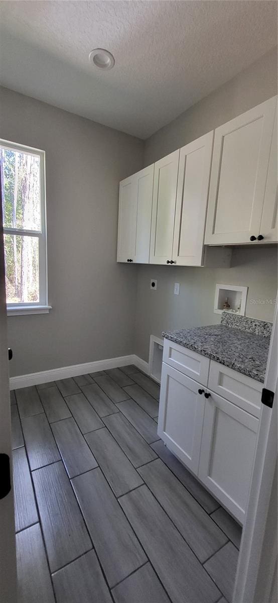 laundry area featuring cabinets, hookup for an electric dryer, a textured ceiling, and washer hookup