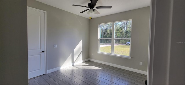 unfurnished room featuring plenty of natural light, ceiling fan, and baseboards