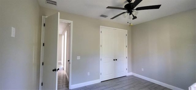 unfurnished bedroom featuring a closet, visible vents, a ceiling fan, and baseboards