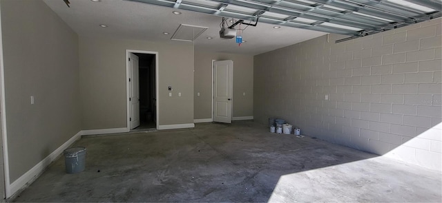 garage featuring a garage door opener and baseboards