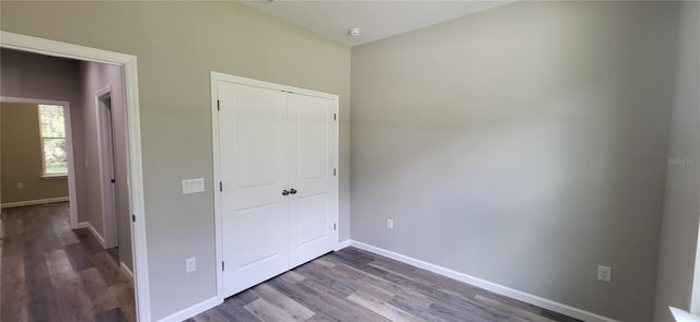 unfurnished bedroom featuring dark hardwood / wood-style floors and a closet