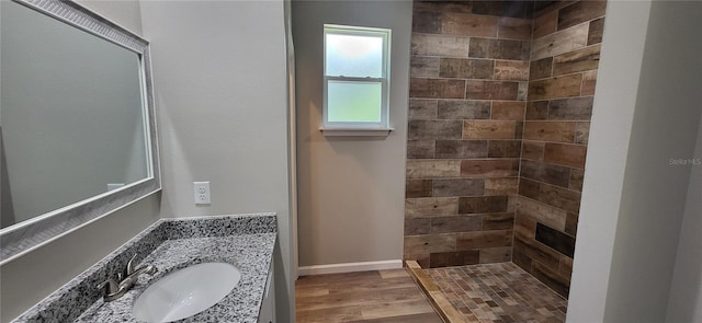 bathroom with vanity, wood-type flooring, and tiled shower