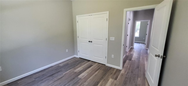 unfurnished bedroom featuring a closet and dark hardwood / wood-style floors