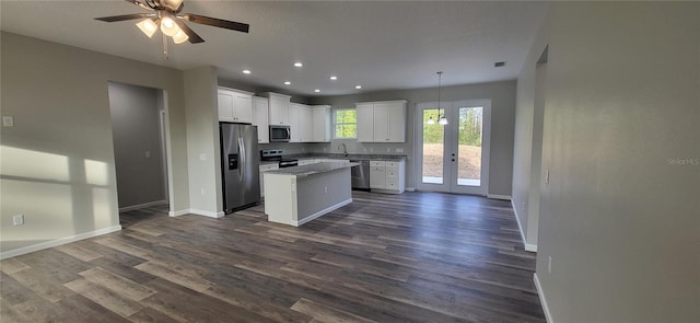 kitchen with decorative light fixtures, ceiling fan, a center island, stainless steel appliances, and white cabinets