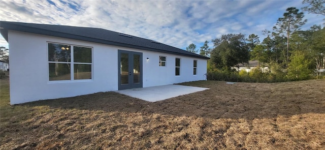 rear view of property with a yard and a patio