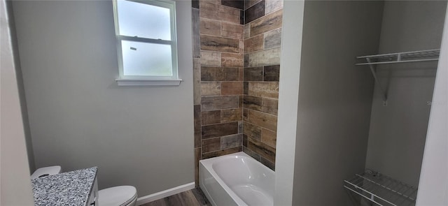 full bathroom featuring toilet, tiled shower / bath, wood-type flooring, and vanity