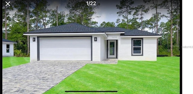 view of front of house featuring a garage and a front lawn