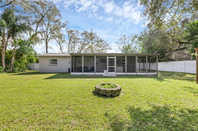 rear view of house with a yard and a sunroom