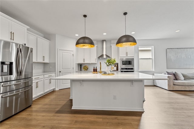 890 Terrapin Dr, Debary, FL 32713 - kitchen with light countertops, wood finished floors, wall chimney exhaust hood, and stainless steel appliances