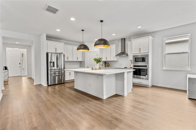 890 Terrapin Dr, Debary, FL 32713 - kitchen with wall chimney range hood, white cabinets, appliances with stainless steel finishes, light countertops, and light wood finished floors