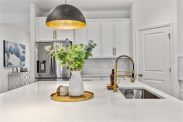 890 Terrapin Dr, Debary, FL 32713 - interior details with white cabinets, stainless steel refrigerator with ice dispenser, light stone counters, a sink, and decorative backsplash