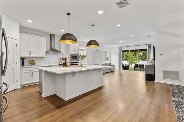 890 Terrapin Dr, Debary, FL 32713 - kitchen featuring open floor plan, appliances with stainless steel finishes, wall chimney range hood, and visible vents