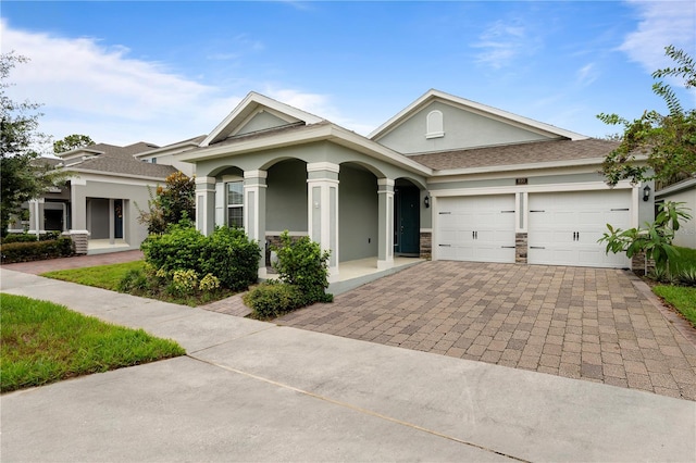 890 Terrapin Dr, Debary, FL 32713 - view of front facade with stucco siding, decorative driveway, a garage, a shingled roof, and covered porch