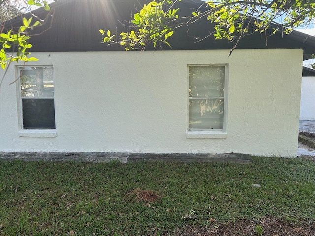 view of side of home with a yard