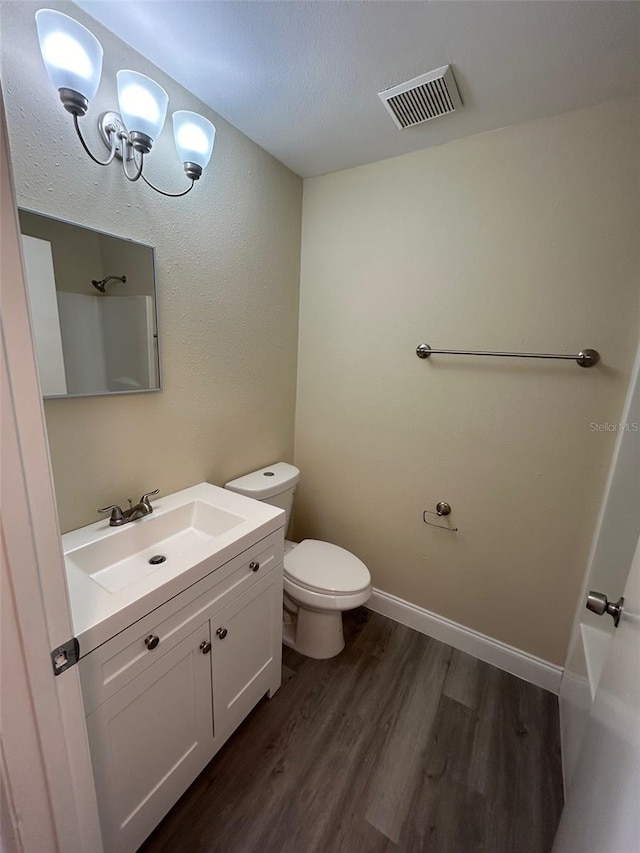 bathroom featuring toilet, hardwood / wood-style floors, and vanity