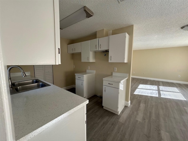 kitchen featuring sink, white cabinetry, hardwood / wood-style flooring, and a textured ceiling