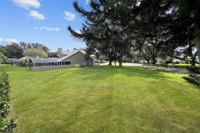 view of yard featuring glass enclosure