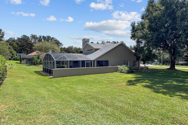 back of house with a yard and a lanai