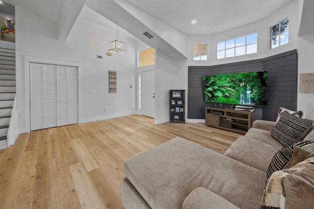 living room featuring a towering ceiling and hardwood / wood-style floors