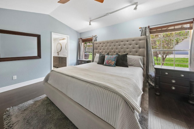 bedroom featuring lofted ceiling, dark hardwood / wood-style flooring, track lighting, and ensuite bathroom