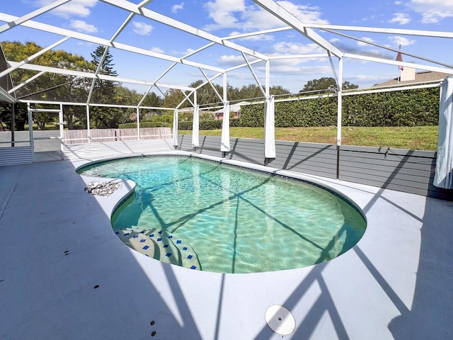 view of swimming pool featuring a lanai and a patio