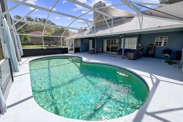 view of pool featuring a patio, a grill, an outdoor hangout area, and glass enclosure