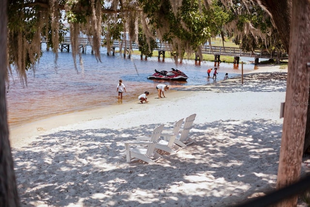 surrounding community featuring a water view and a beach view