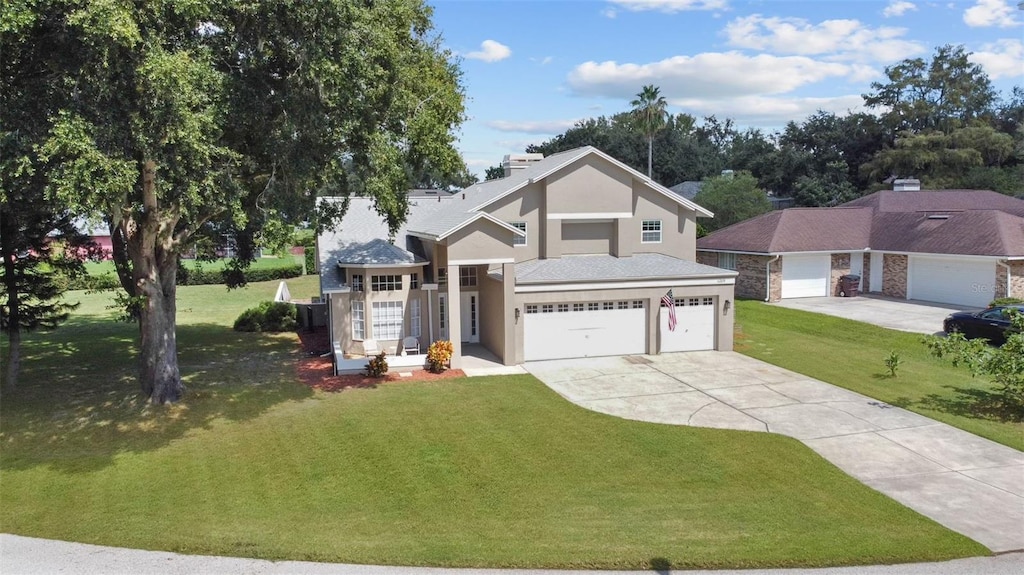 view of front facade with stucco siding, a front lawn, driveway, and a garage
