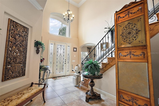 212 Crestrun Loop, Leesburg, FL 34748 - foyer featuring arched walkways, crown molding, healthy amount of natural light, a chandelier, and stairs