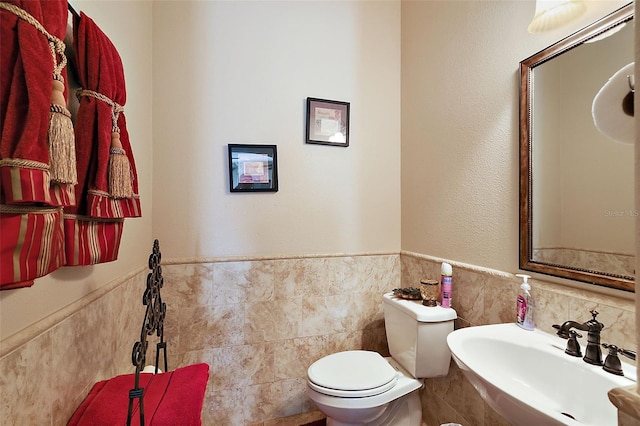 212 Crestrun Loop, Leesburg, FL 34748 - half bath with tile walls, a sink, toilet, and wainscoting