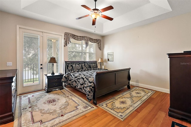 212 Crestrun Loop, Leesburg, FL 34748 - bedroom featuring a raised ceiling, access to exterior, wood finished floors, baseboards, and a ceiling fan