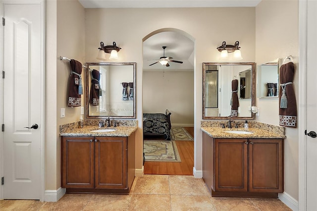 212 Crestrun Loop, Leesburg, FL 34748 - ensuite bathroom with ceiling fan, two vanities, baseboards, and tile patterned floors