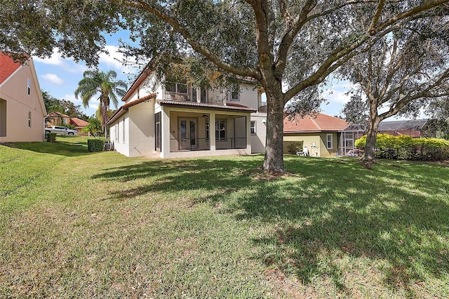 212 Crestrun Loop, Leesburg, FL 34748 - back of house with a balcony, a lawn, and stucco siding