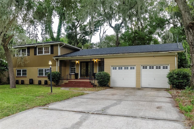 tri-level home featuring a porch, a front yard, and a garage