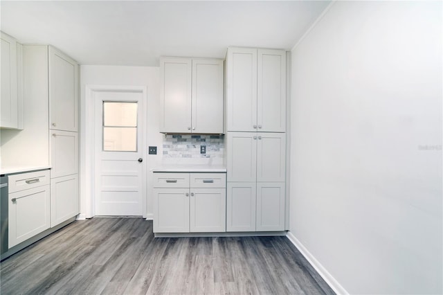 kitchen featuring crown molding, light hardwood / wood-style floors, decorative backsplash, and white cabinetry