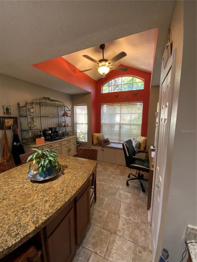 kitchen featuring vaulted ceiling, a textured ceiling, and ceiling fan