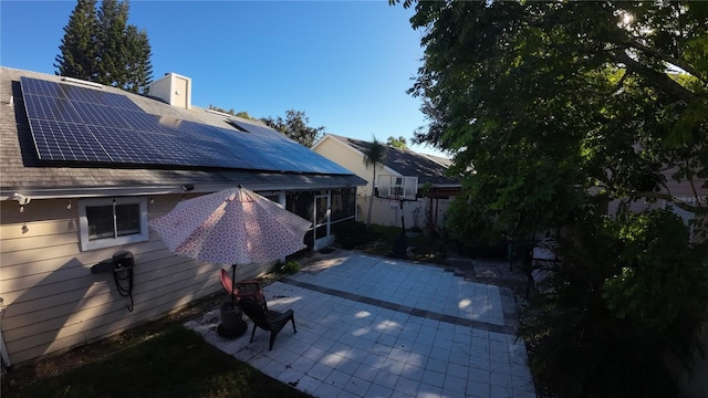 2939 Falling Tree Cir, Orlando, FL 32837 - view of side of property featuring a patio area, solar panels, a chimney, a sunroom, and fence
