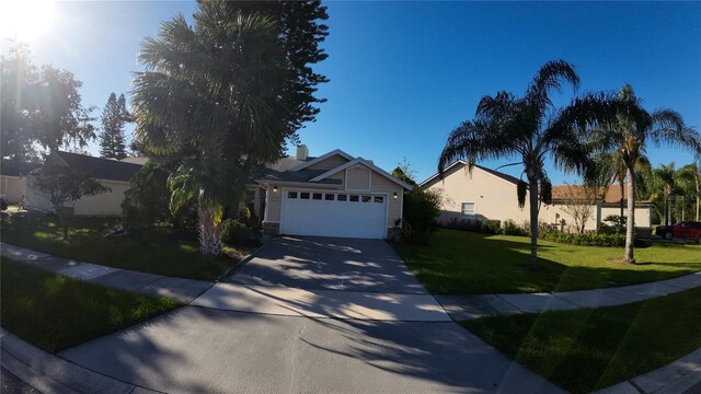2939 Falling Tree Cir, Orlando, FL 32837 - view of front of house featuring a front lawn, a garage, driveway, and a chimney