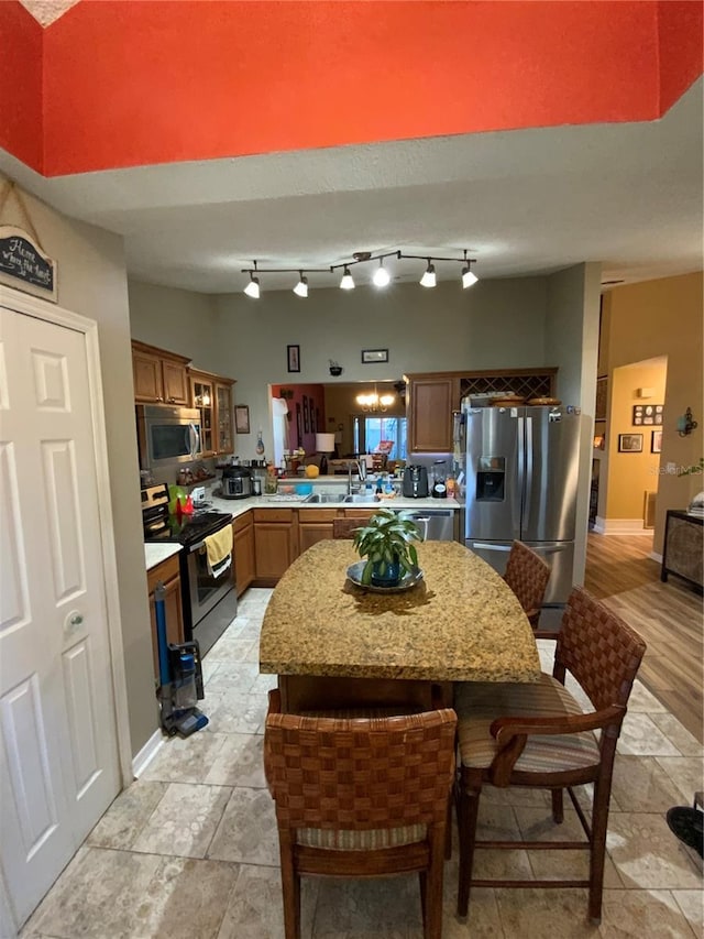 kitchen with appliances with stainless steel finishes, kitchen peninsula, sink, and a kitchen bar