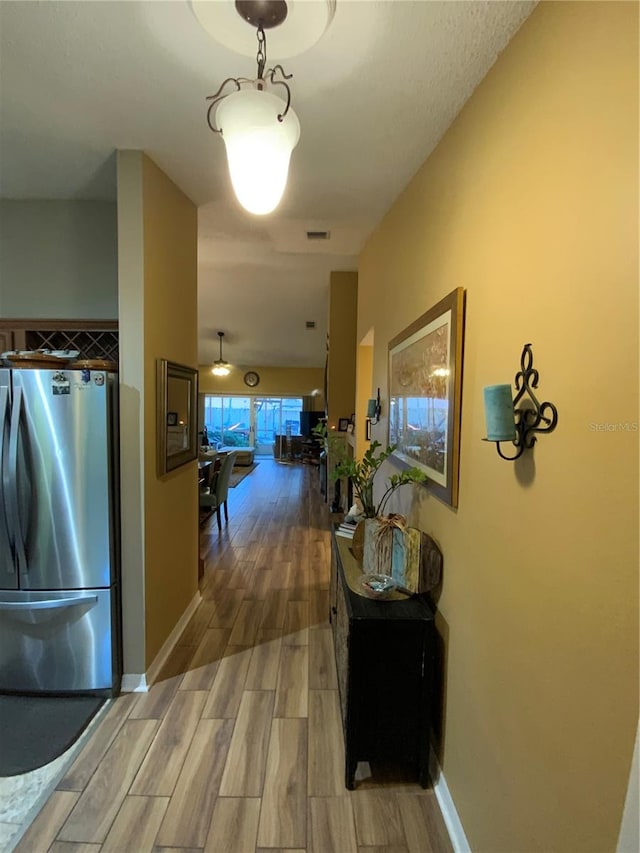 hallway with light hardwood / wood-style floors