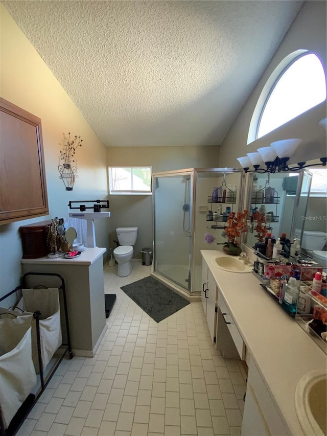 bathroom featuring a shower with door, a textured ceiling, toilet, vanity, and tile patterned floors