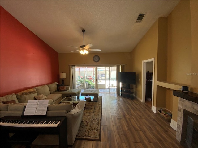 2939 Falling Tree Cir, Orlando, FL 32837 - living room featuring ceiling fan, dark wood-style flooring, a stone fireplace, a textured ceiling, and high vaulted ceiling