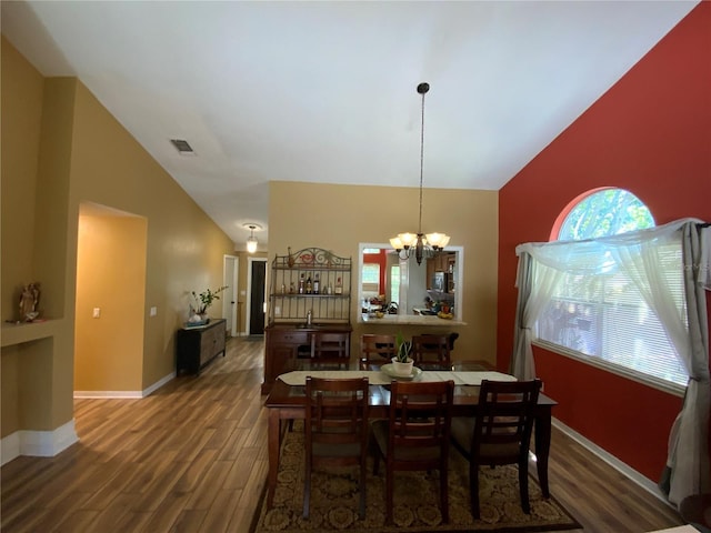 2939 Falling Tree Cir, Orlando, FL 32837 - dining area featuring high vaulted ceiling, wood finished floors, and a chandelier