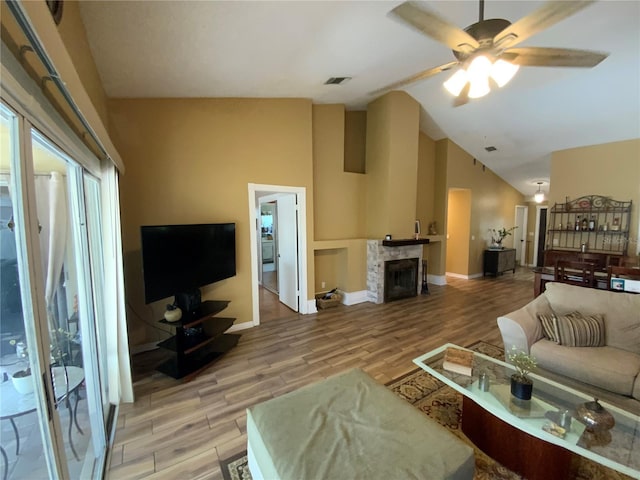 2939 Falling Tree Cir, Orlando, FL 32837 - living area featuring light wood-type flooring, vaulted ceiling, a ceiling fan, and a stone fireplace