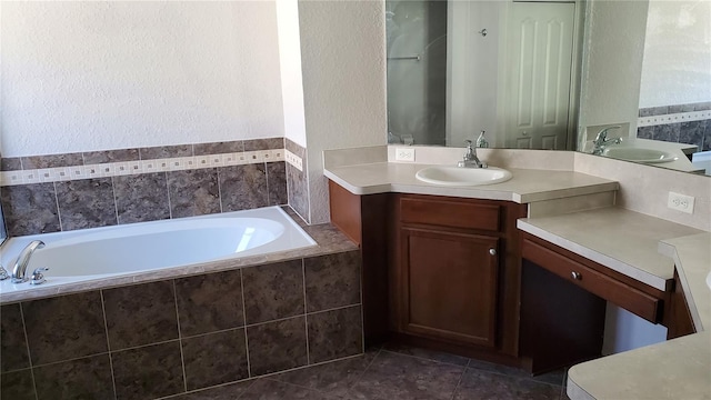 bathroom featuring vanity, a relaxing tiled tub, and tile patterned floors