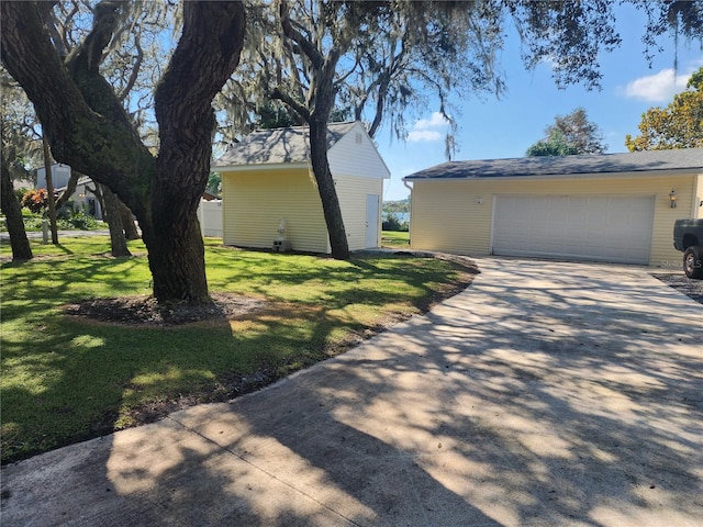 view of home's exterior with a yard, a garage, and an outdoor structure