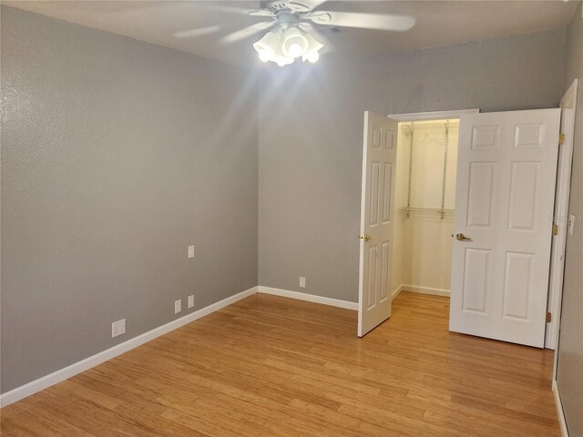 14902 Arrena Rd, Winter Garden, FL 34787 - unfurnished bedroom with light wood-type flooring, baseboards, a walk in closet, ceiling fan, and a closet