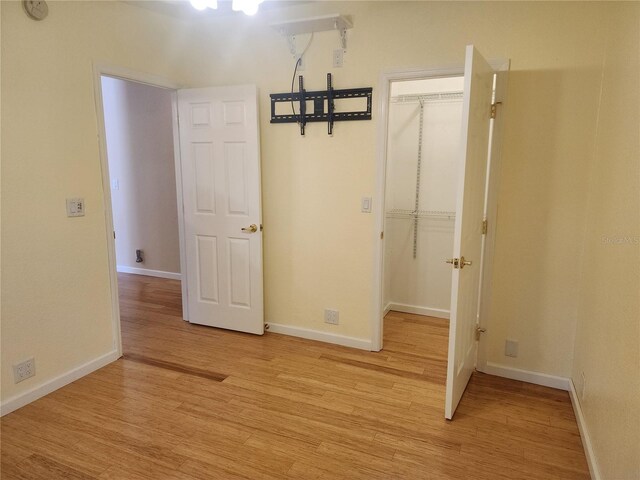 14902 Arrena Rd, Winter Garden, FL 34787 - unfurnished bedroom with a walk in closet, light wood finished floors, and a closet