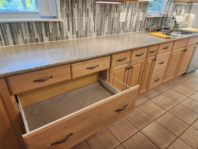 kitchen featuring a healthy amount of sunlight, light tile patterned floors, and backsplash